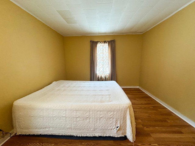 bedroom featuring baseboards and dark wood-style flooring