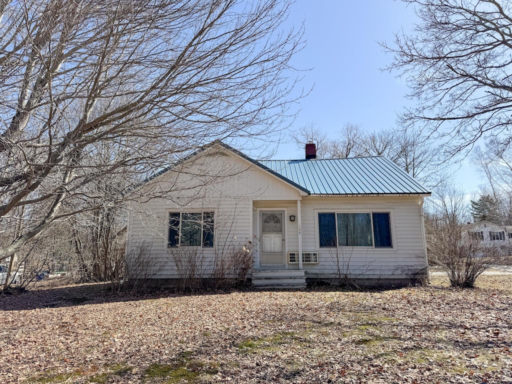 108 Enfield Rd, Lincoln, ME 04457 - view of front facade with metal roof and a chimney