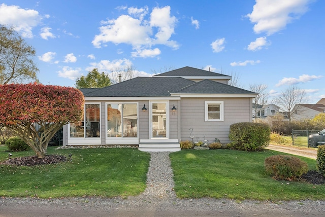 bungalow-style house with a front yard and a shingled roof