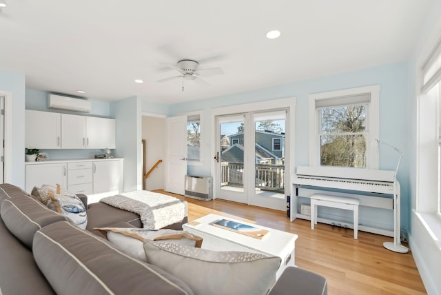 living room with an AC wall unit, recessed lighting, and light wood finished floors