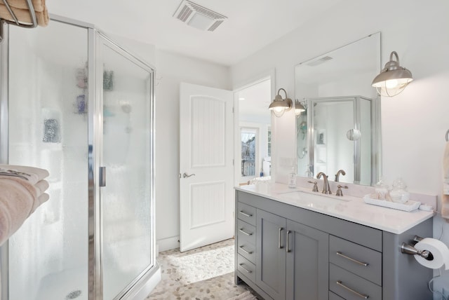 full bathroom with visible vents, vanity, and a shower stall