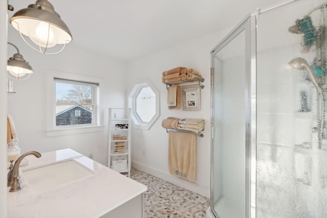 bathroom with a shower stall, baseboards, and a sink