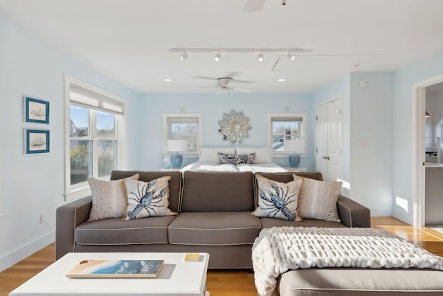 living area featuring plenty of natural light, light wood-style flooring, and a ceiling fan