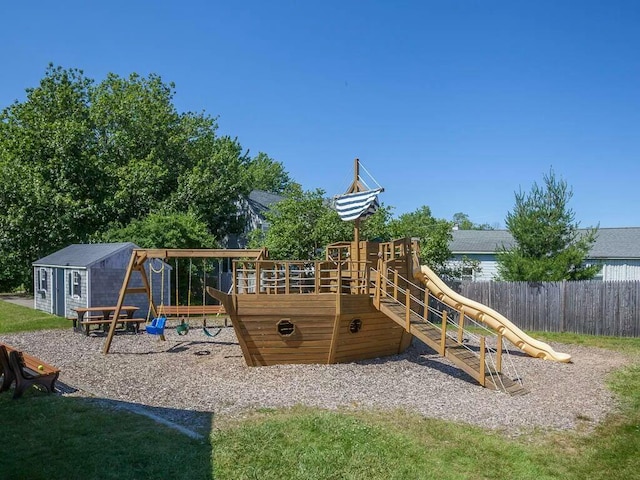 view of playground with an outbuilding and fence