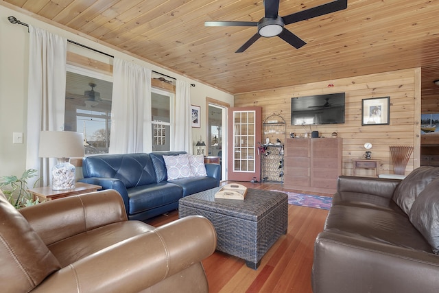 living room featuring a ceiling fan, wood finished floors, wood walls, and wooden ceiling