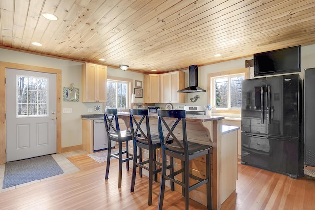kitchen featuring recessed lighting, wall chimney exhaust hood, appliances with stainless steel finishes, and light wood-style floors