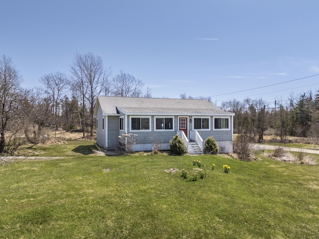 view of front of property featuring a shingled roof, a front yard, and entry steps