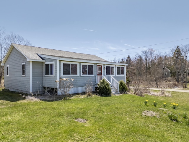single story home featuring roof with shingles and a front lawn