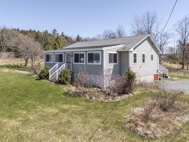view of front of home featuring a shingled roof and a front lawn