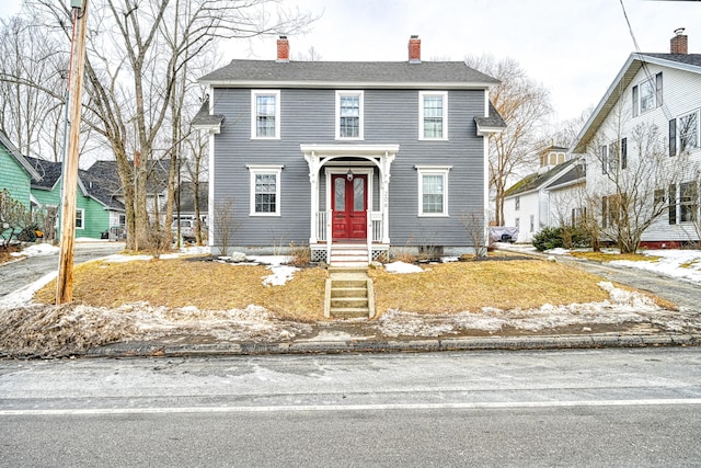 view of front of house with roof with shingles and a chimney