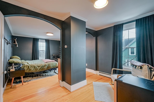 bedroom featuring wood finished floors, baseboards, a baseboard radiator, arched walkways, and ornamental molding