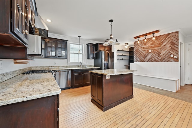 kitchen featuring light wood-style floors, appliances with stainless steel finishes, ornamental molding, and dark brown cabinets