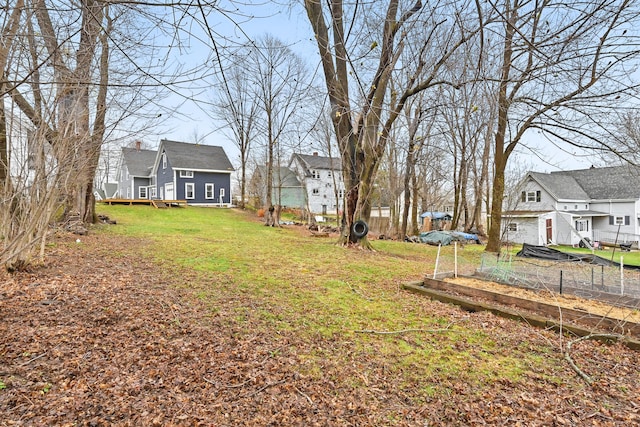 view of yard featuring a residential view and a vegetable garden