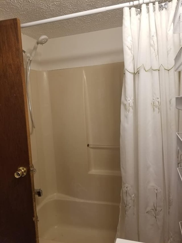 bathroom featuring a textured ceiling and shower / bath combo