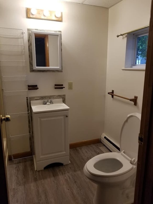 bathroom featuring baseboard heating, vanity, baseboards, and wood finished floors