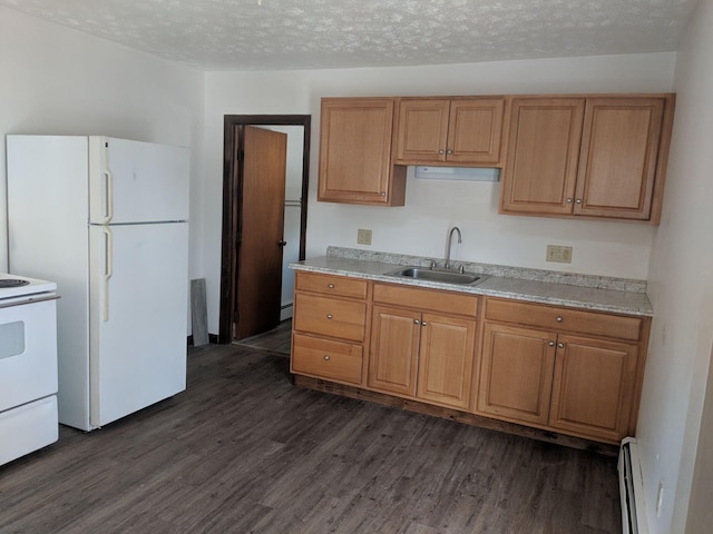 kitchen featuring white appliances, dark wood-style floors, a sink, a textured ceiling, and baseboard heating