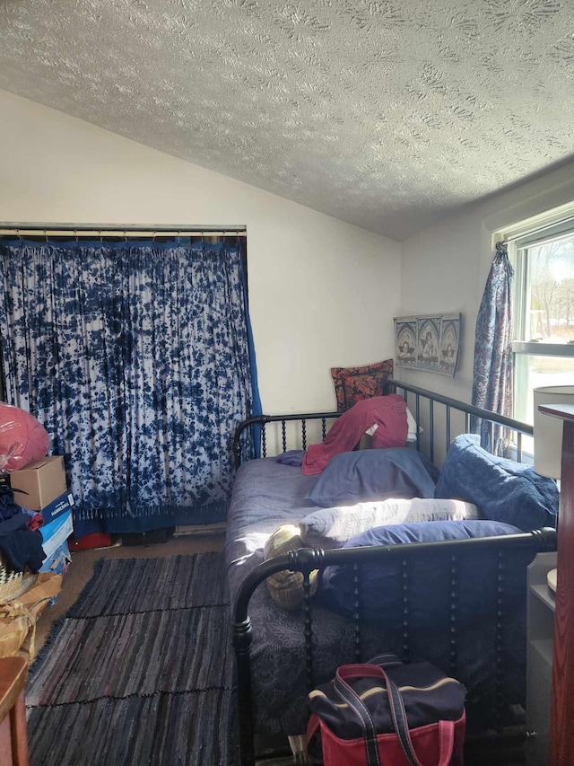 bedroom featuring a textured ceiling and lofted ceiling