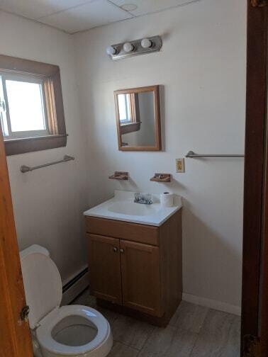 bathroom with vanity, toilet, baseboards, and baseboard heating