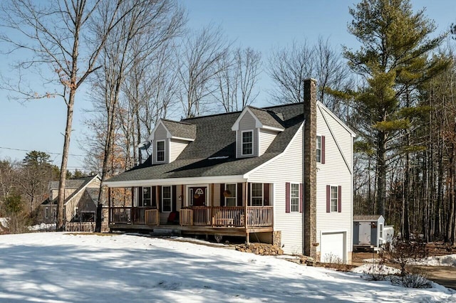 cape cod home with covered porch, an attached garage, a chimney, and a shingled roof