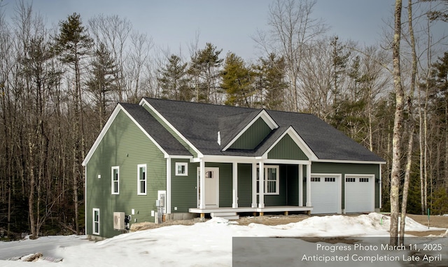 view of front facade featuring a porch, an attached garage, and roof with shingles