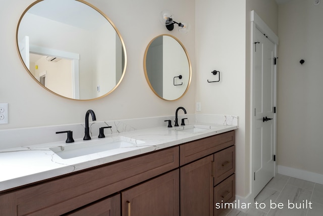 bathroom featuring double vanity, baseboards, and a sink