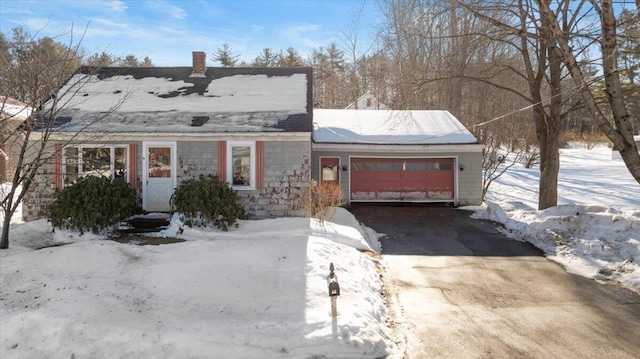 view of front of property featuring an attached garage, a chimney, and driveway