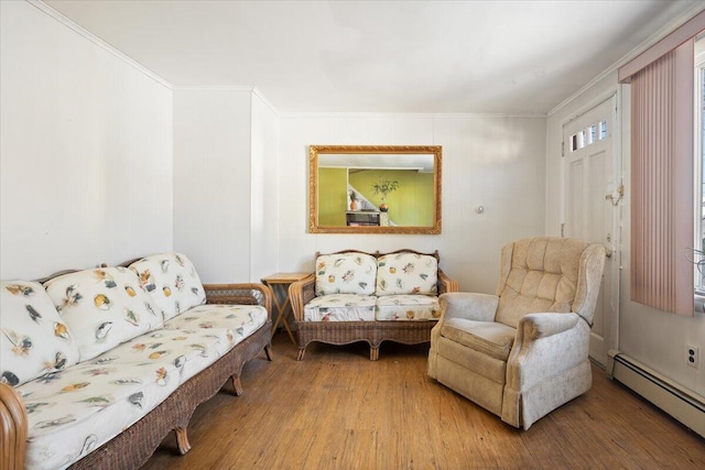 living area featuring crown molding, a baseboard heating unit, and wood finished floors