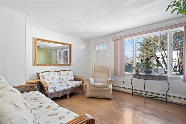 living room featuring a baseboard heating unit, wood finished floors, and ornamental molding