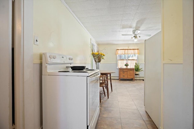 kitchen with white range with electric cooktop, light tile patterned flooring, ceiling fan, a baseboard heating unit, and crown molding