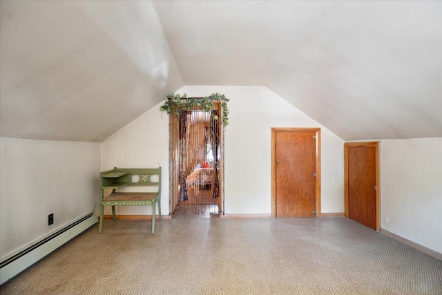 additional living space with baseboards, baseboard heating, and vaulted ceiling