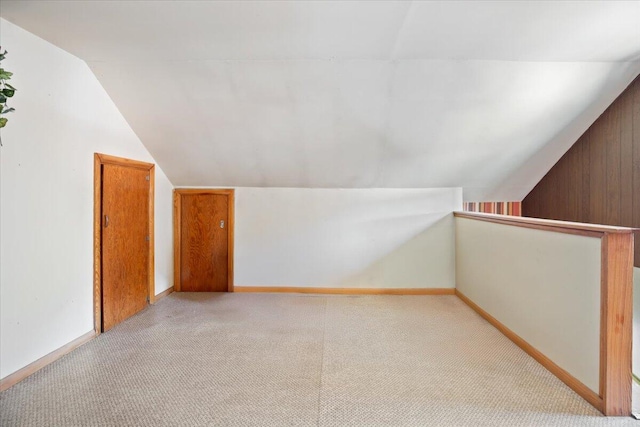 bonus room featuring carpet flooring, baseboards, and lofted ceiling