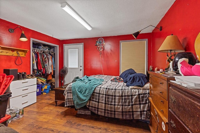 bedroom featuring a closet, a textured ceiling, and wood finished floors