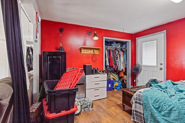 bedroom featuring a closet, a textured ceiling, and wood finished floors