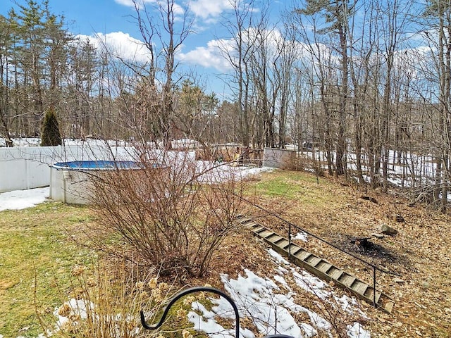 snowy yard featuring a fenced in pool and fence