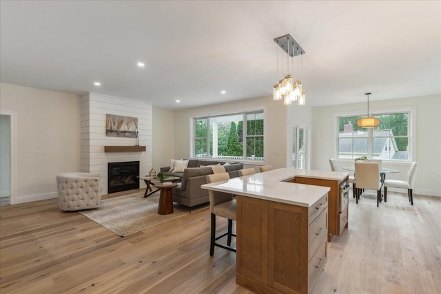 75 Main St, York, ME 03909 - kitchen featuring light countertops, light wood finished floors, a large fireplace, hanging light fixtures, and recessed lighting
