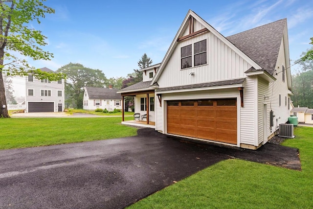 75 Main St, York, ME 03909 - modern farmhouse with board and batten siding, roof with shingles, a garage, a front yard, and asphalt driveway