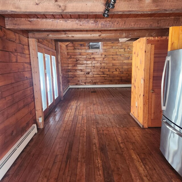 interior space with beamed ceiling, baseboard heating, dark wood finished floors, and wood walls