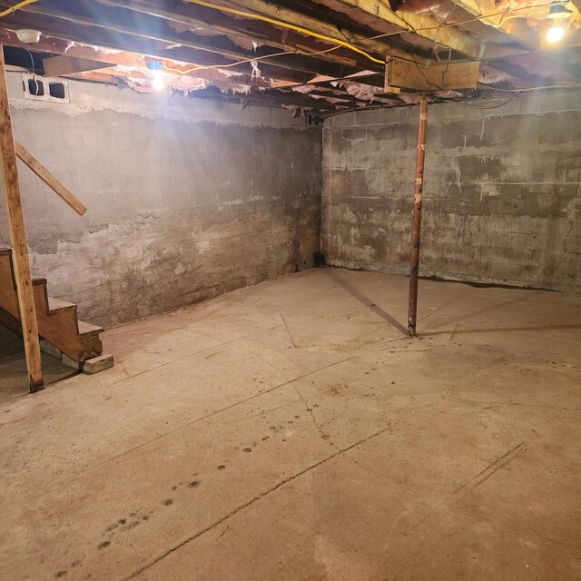 unfinished basement featuring stairs