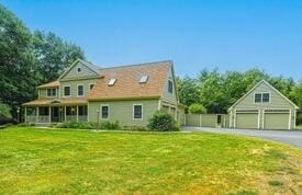 view of front of house with a front yard, an outbuilding, and a garage