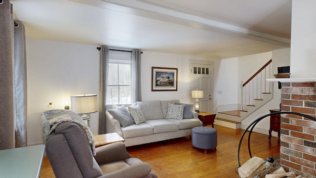 living room featuring hardwood / wood-style flooring, stairway, and baseboards