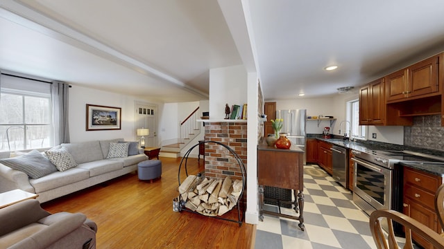 kitchen with stainless steel appliances, plenty of natural light, light floors, and open floor plan