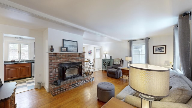 living room with a brick fireplace and light wood-style floors