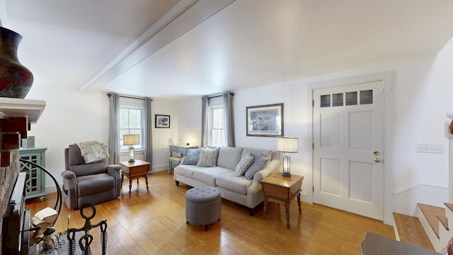 living room featuring beam ceiling and light wood-type flooring