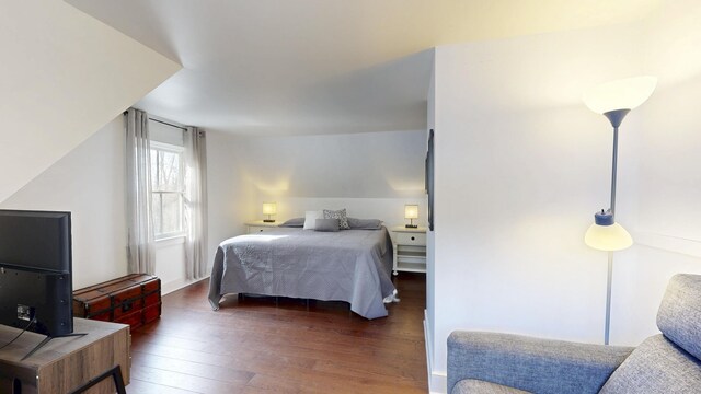 bedroom with lofted ceiling and hardwood / wood-style flooring