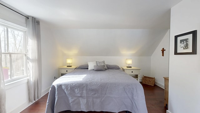 bedroom featuring multiple windows, dark wood-type flooring, and vaulted ceiling