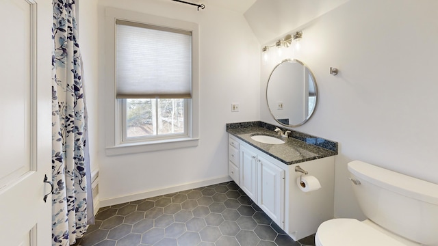 bathroom featuring curtained shower, toilet, vanity, and baseboards