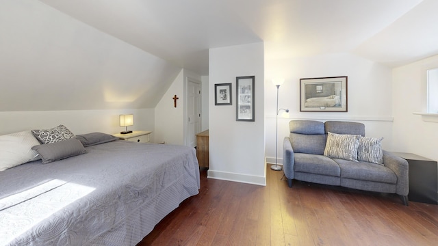 bedroom featuring wood finished floors, baseboards, and vaulted ceiling