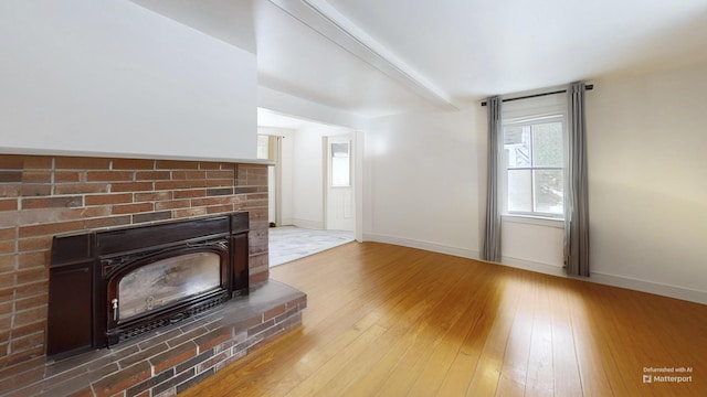 unfurnished living room with baseboards and hardwood / wood-style flooring