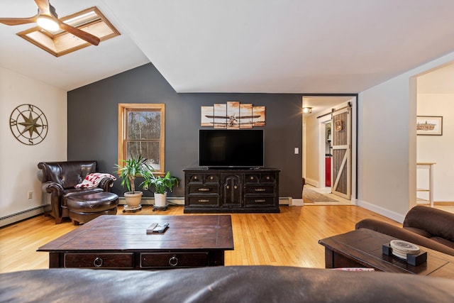 living room with a baseboard radiator, vaulted ceiling with skylight, baseboards, and wood finished floors