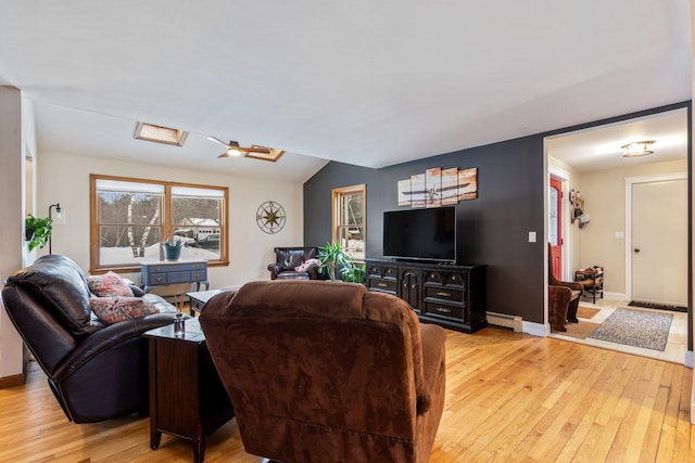 living area with lofted ceiling, light wood-style flooring, baseboards, and baseboard heating